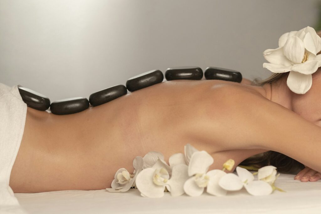 Client relaxing during a spa treatment with smooth black stones