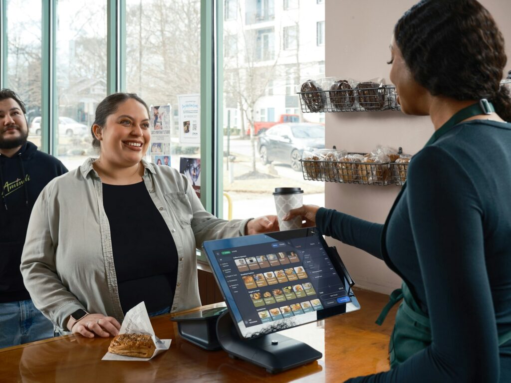 Smiling customer at a cafe counter, the right moment to ask how to get more Google reviews
