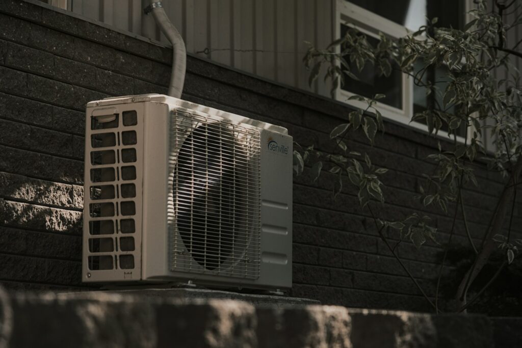 White air conditioner unit mounted on a brick wall