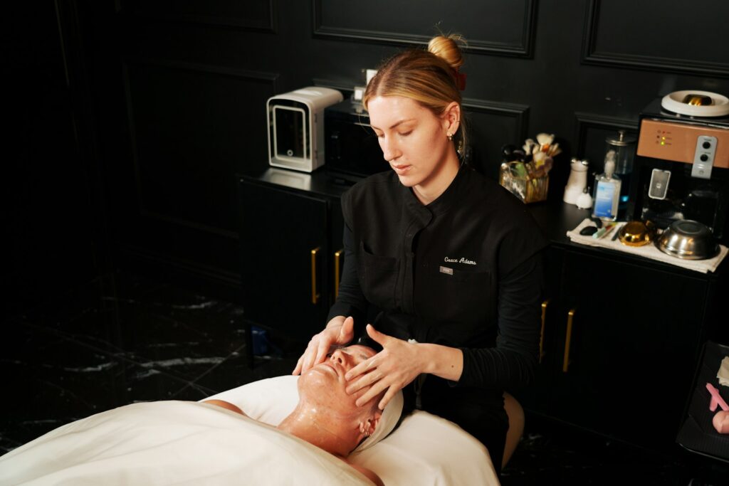 Esthetician performing a facial treatment on a med spa client