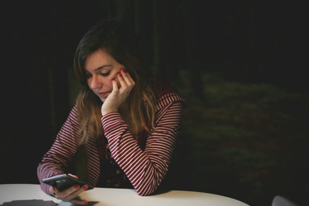 Business owner reading a review on her phone, deciding how to respond to negative reviews